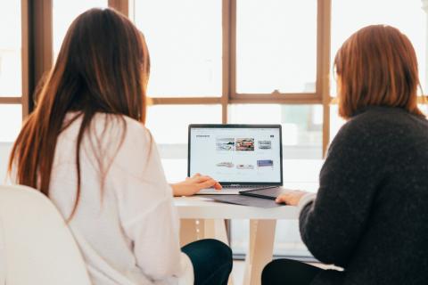 Two people looking at a laptop